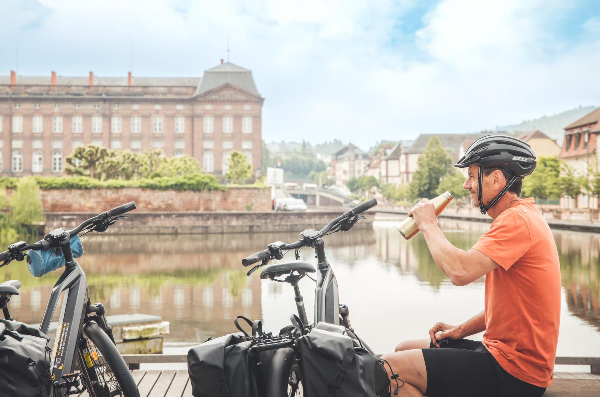 Cyclistes en pause au port de Saverne, vélos posés devant le château